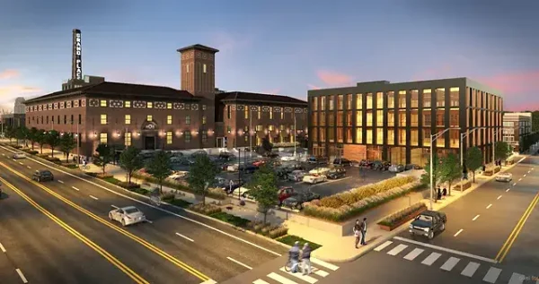 Modern PACE center with parking lot and vibrant urban surroundings at sunset.