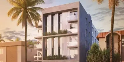 Modern multi-story residential building with balconies and lush greenery in a tropical setting.