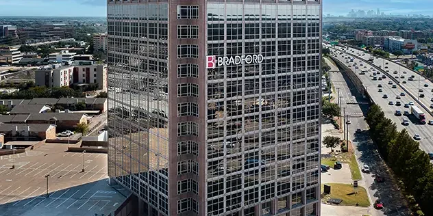 Modern office building with Walters Balido & Crain and Bradford logos in a cityscape view.