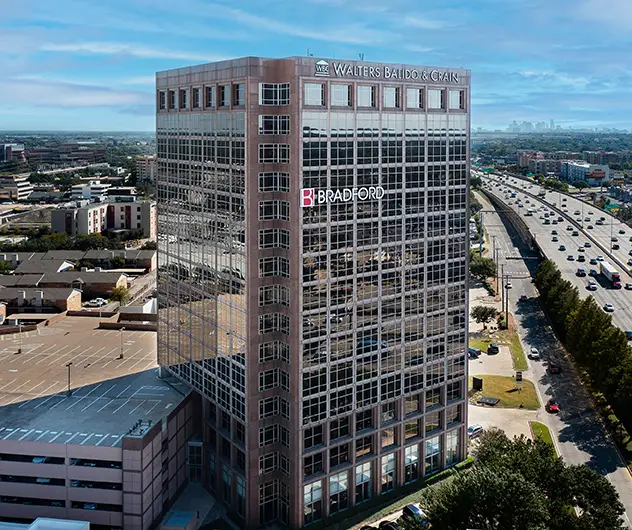 Modern office building with Walters Balido & Crain and Bradford logos in a cityscape view.