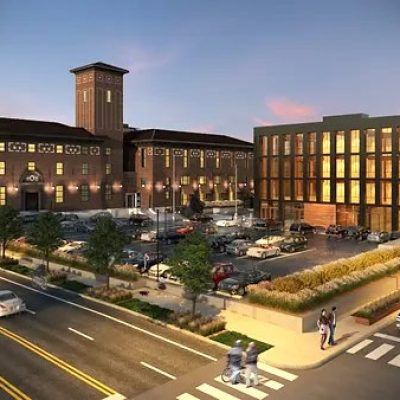 Modern PACE center with parking lot and vibrant urban surroundings at sunset.