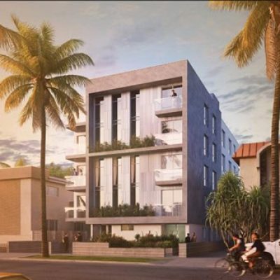 Modern multi-story residential building with balconies and lush greenery in a tropical setting.