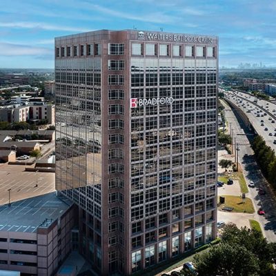 Modern office building with Walters Balido & Crain and Bradford logos in a cityscape view.